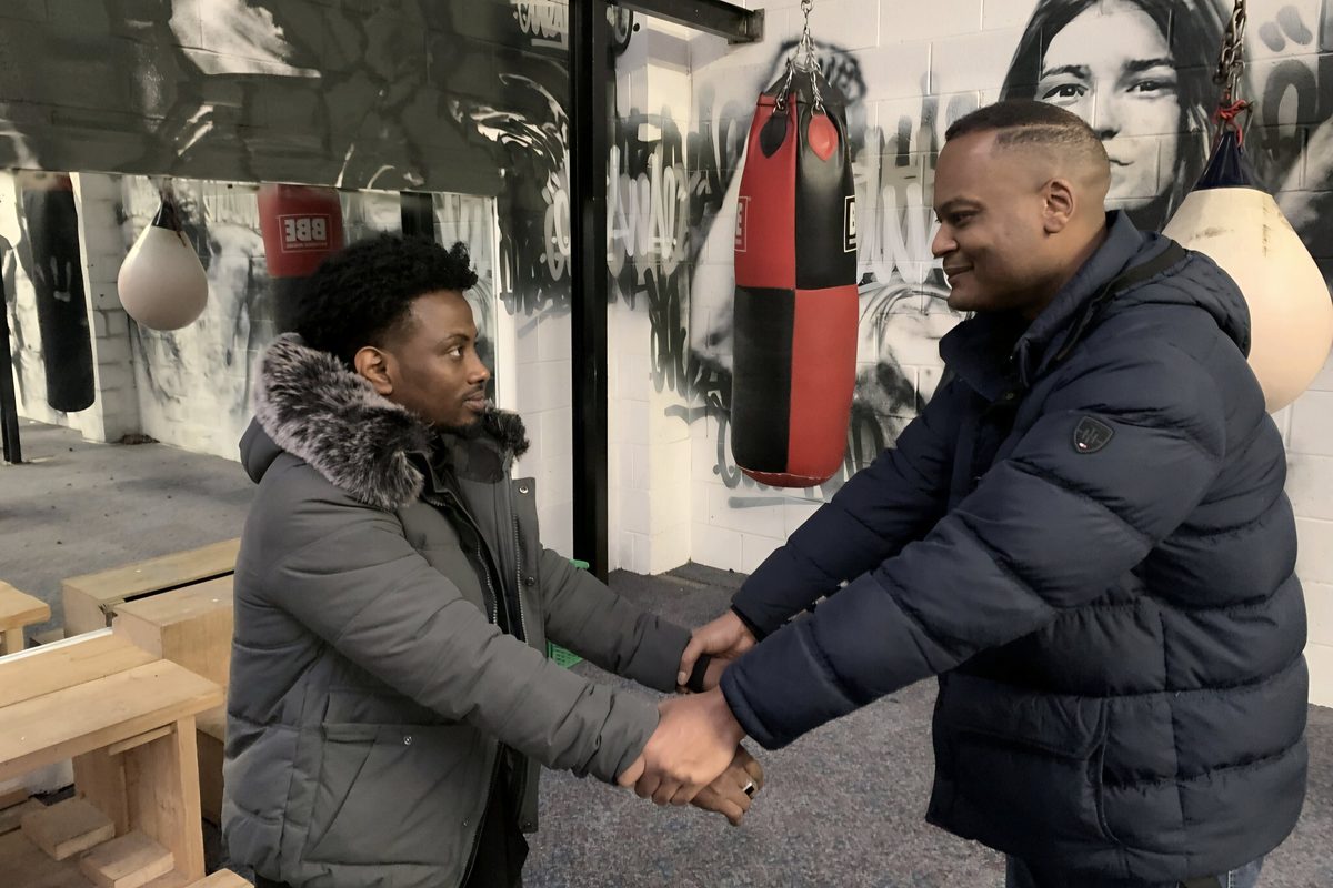 A trainer shaking hands with a candidate at the training venue.